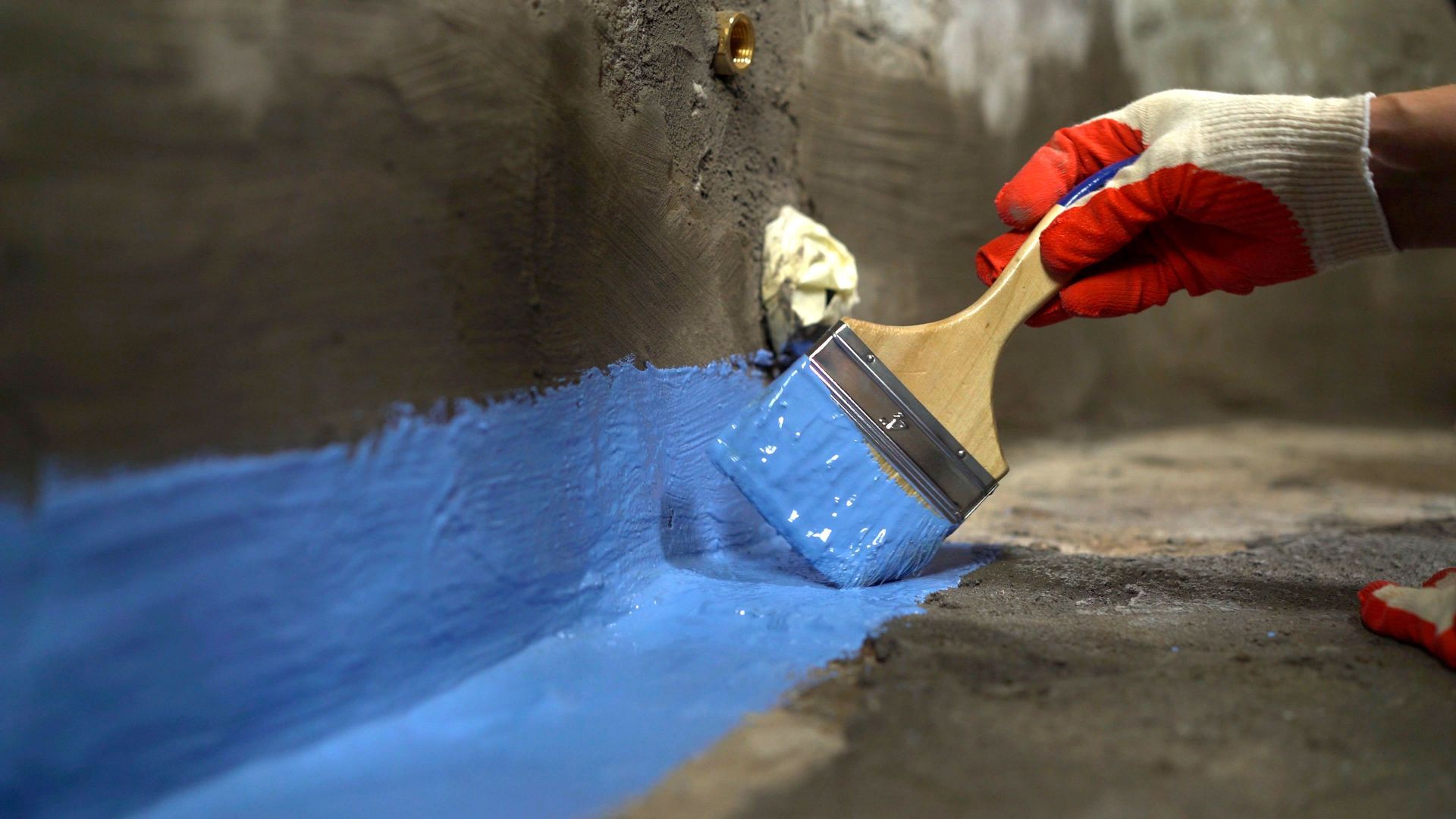 A person is painting a wall with a brush.