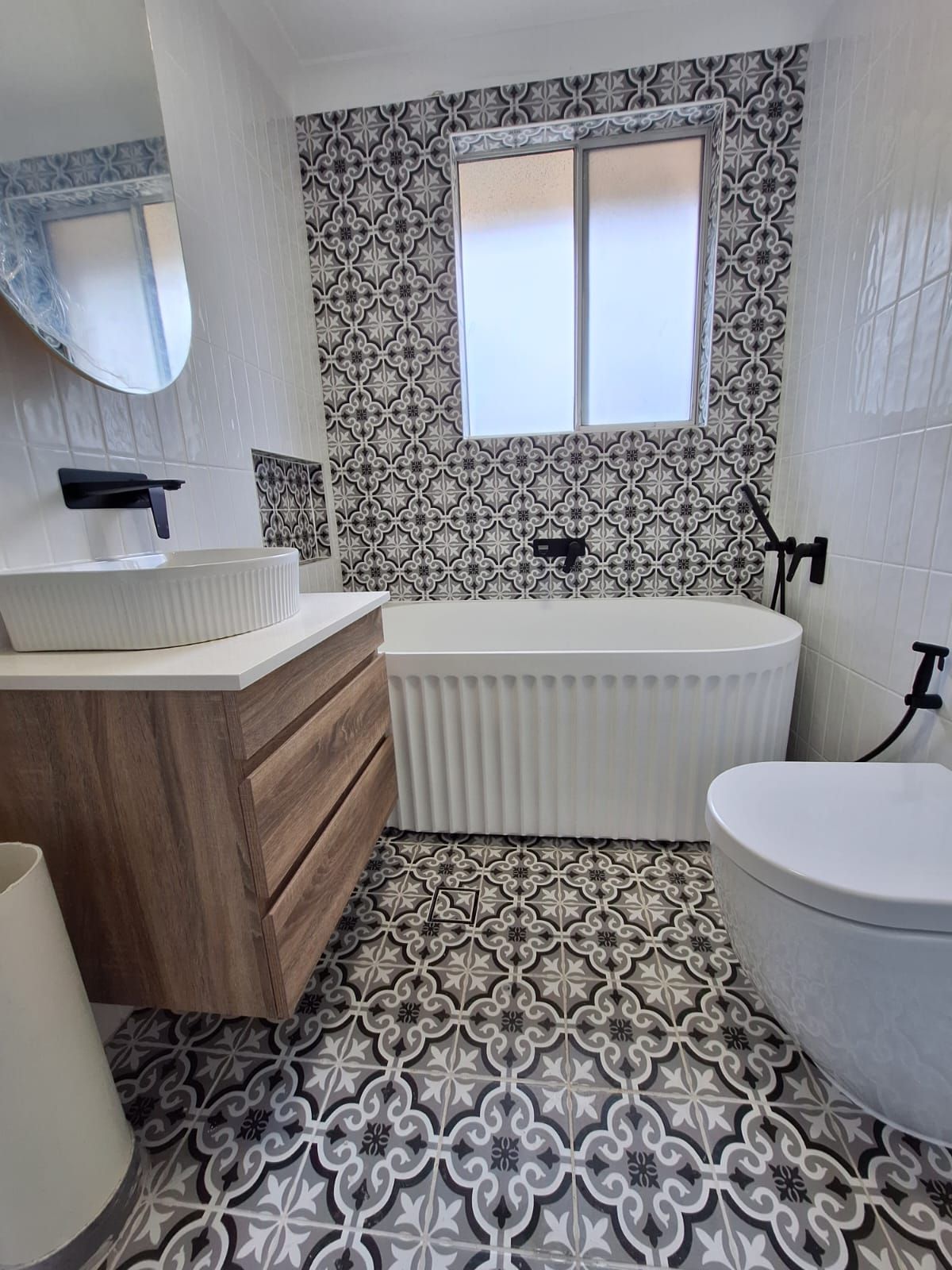 A bathroom with a bathtub , sink , toilet and mirror.