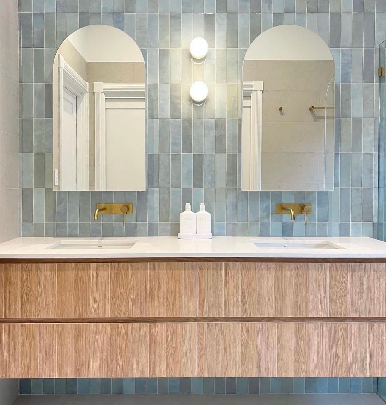 A bathroom with two sinks and two mirrors.