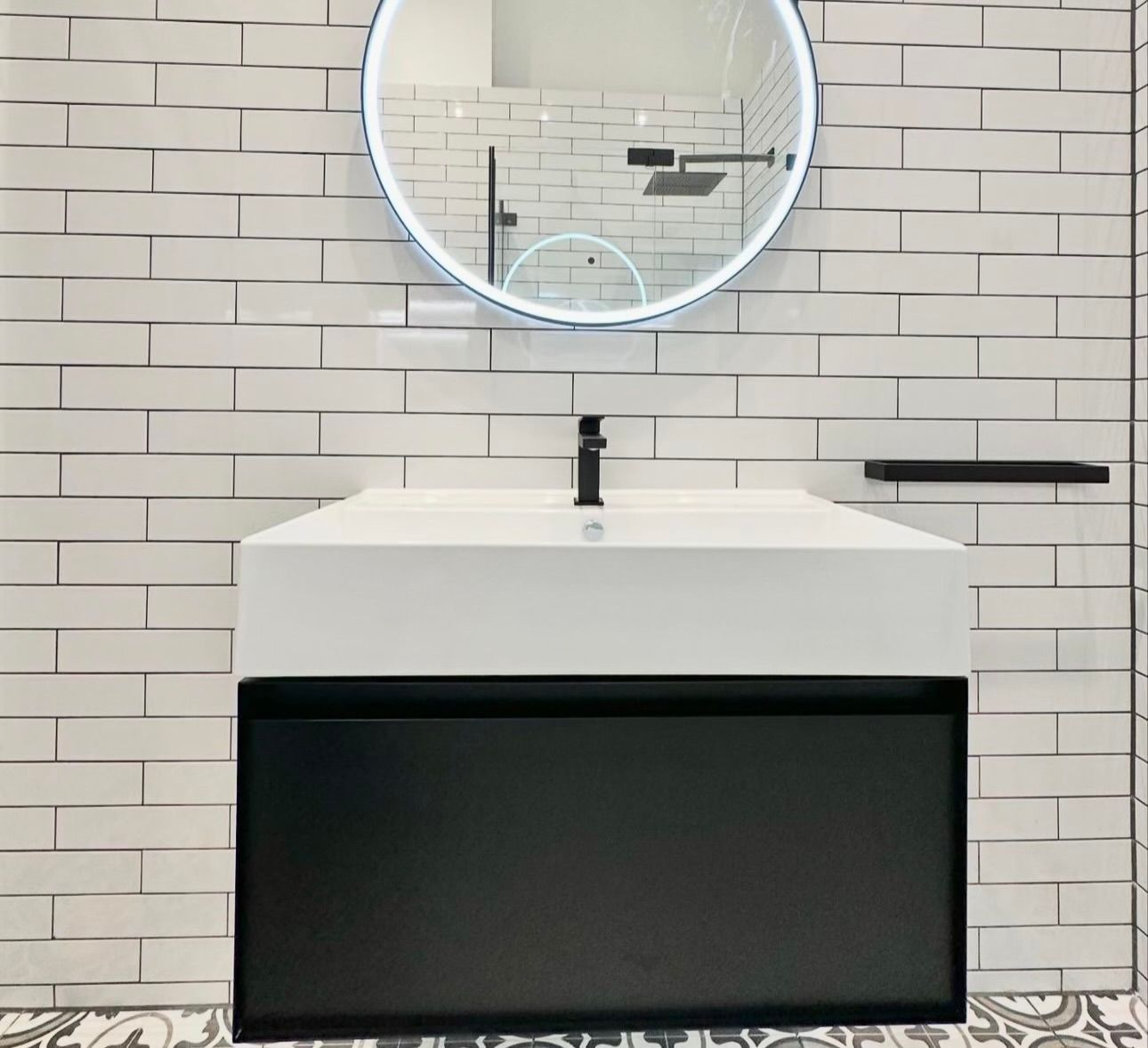 A bathroom with a sink and a mirror on the wall