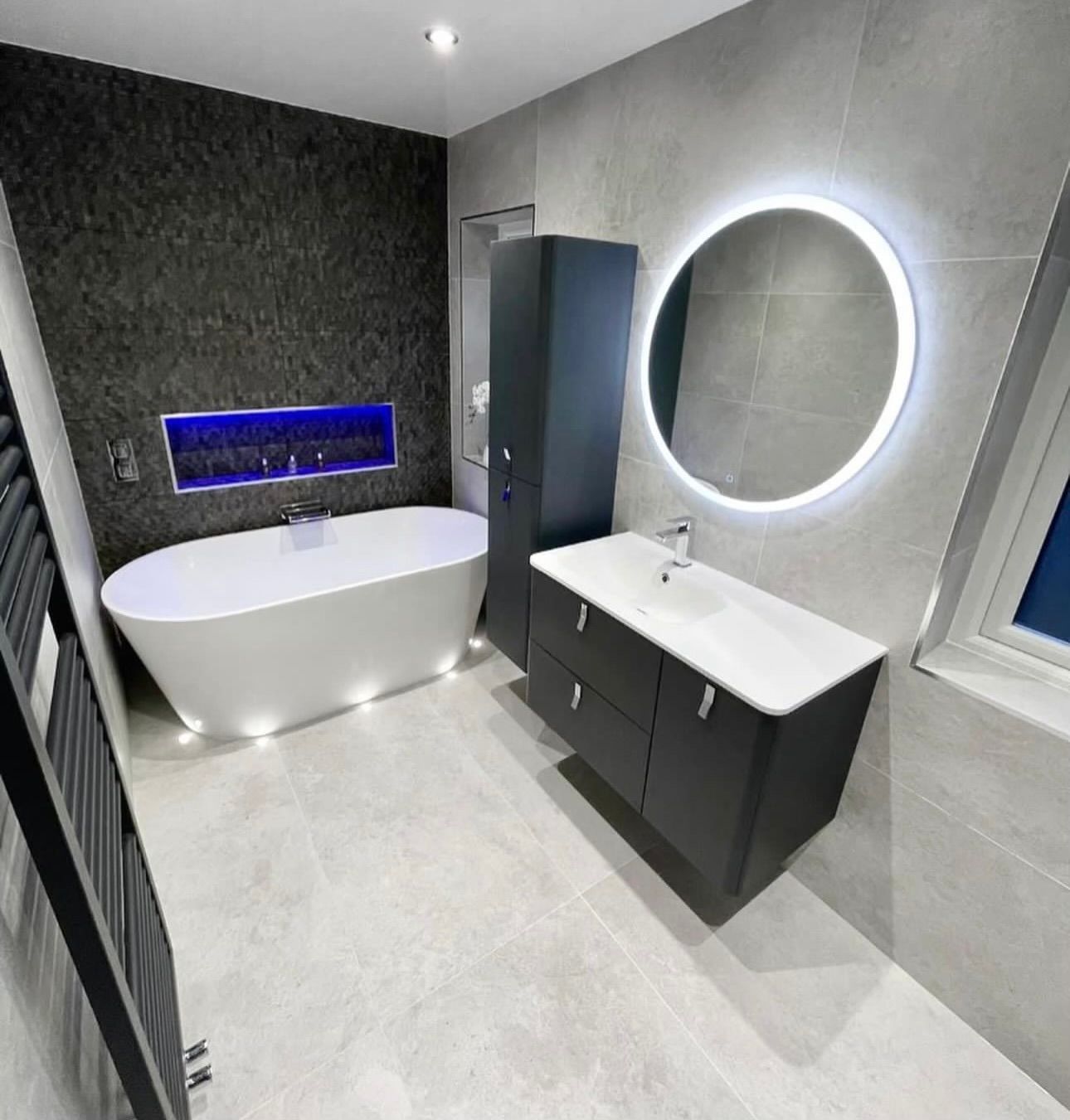 A bathroom with a bathtub , sink and mirror