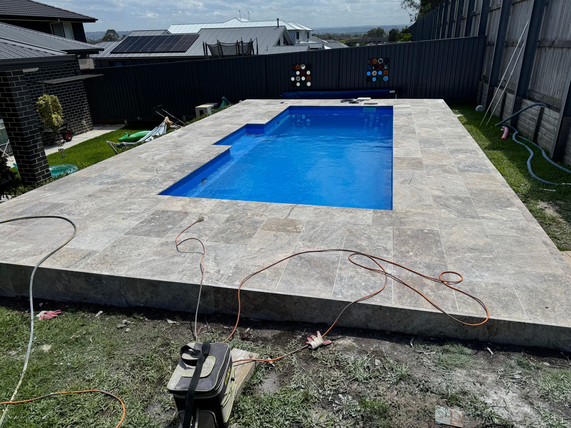A large swimming pool is being built in a backyard.