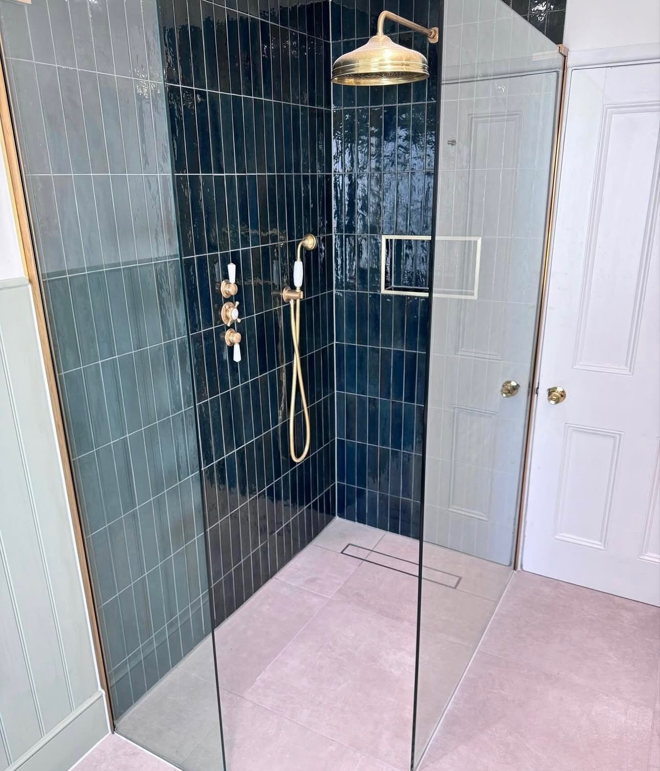 A bathroom with a walk in shower and a shower head.