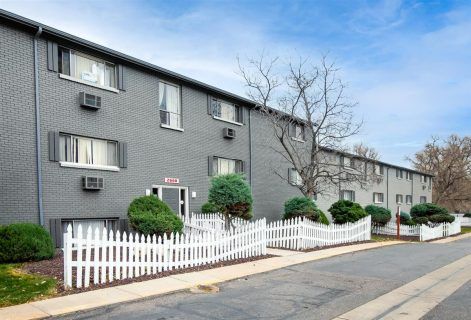 Photo of a building showing a white picket fence surrounding some parts