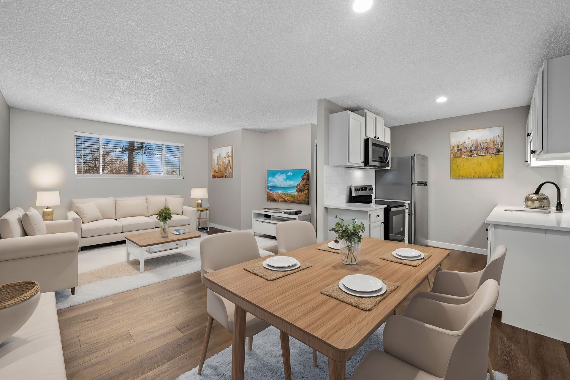 Photo of a dining area in the foreground, and a living room in the background