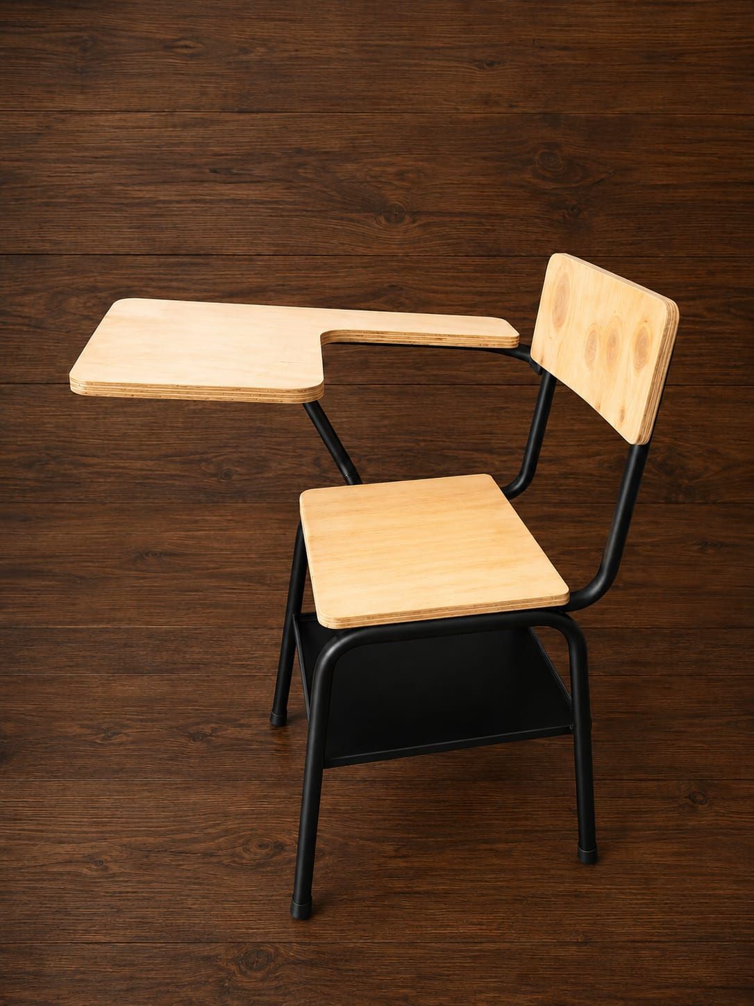 Pupitre y silla de madera con estructura de metal negro sobre un suelo de madera.