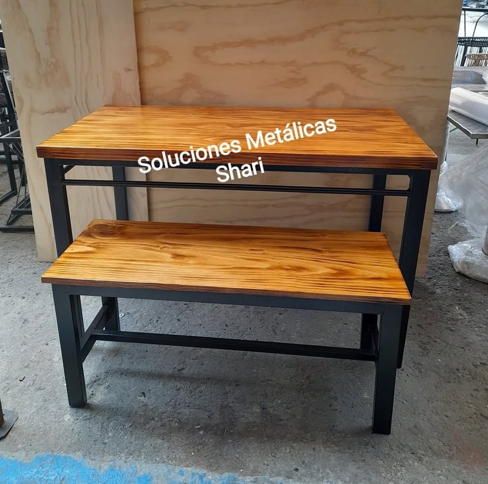 Banco de madera de dos niveles con estructura de metal negro en un taller, etiquetado como “soluciones Metálicas Shari”.