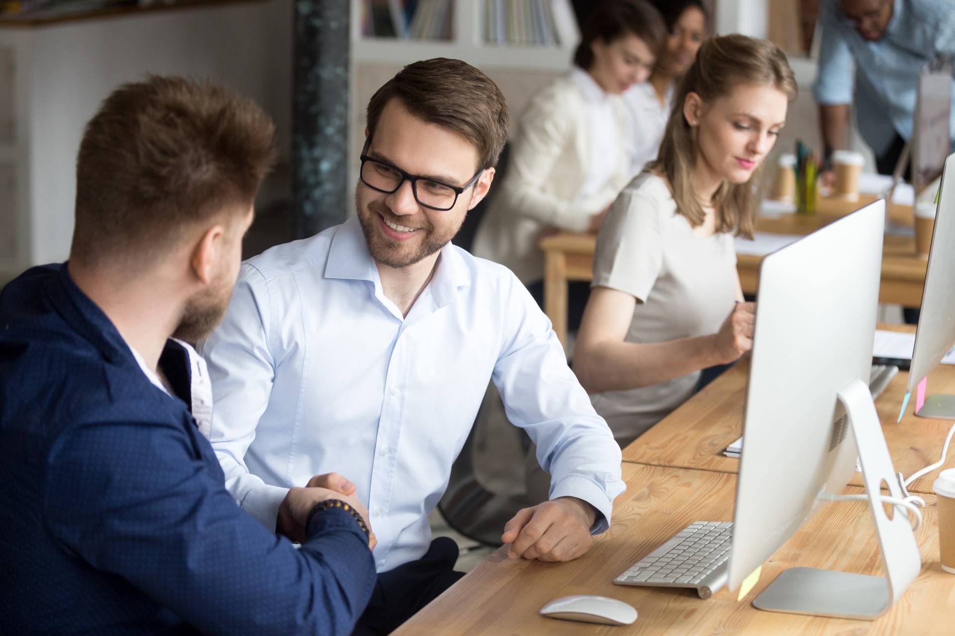Business meeting with people discussing documents beside a laptop and tablet