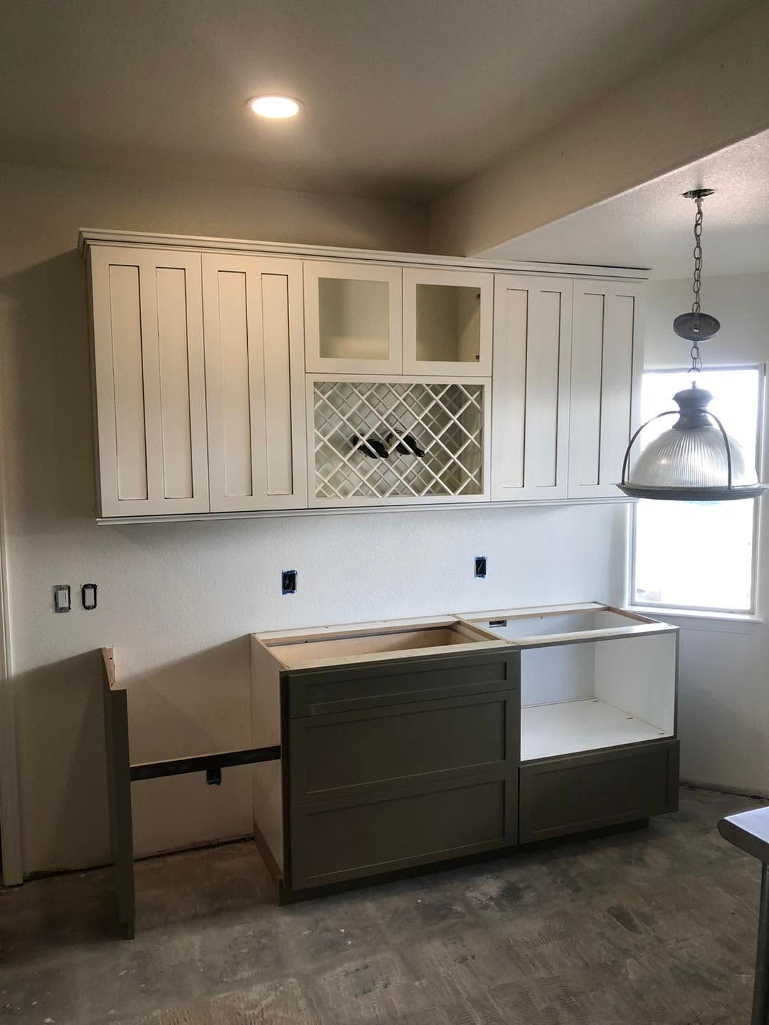 Small kitchen with white cabinets, dark lower cabinets, a sink, and a hanging pendant light.