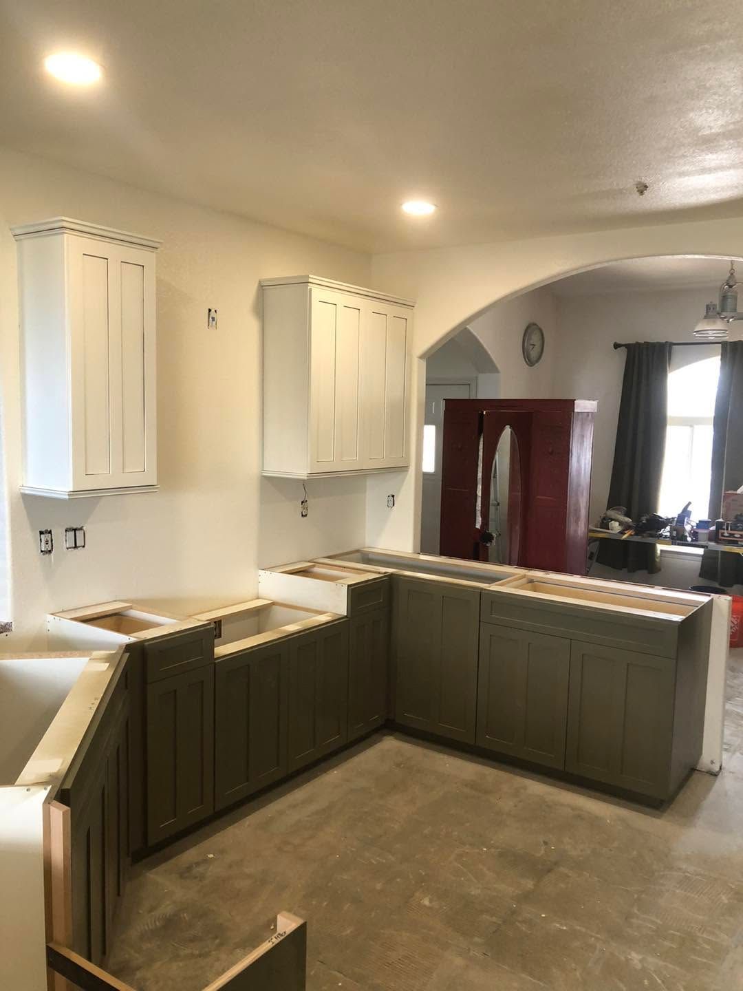 Partially renovated kitchen with white cabinets, green lower cabinets, and a peninsula counter