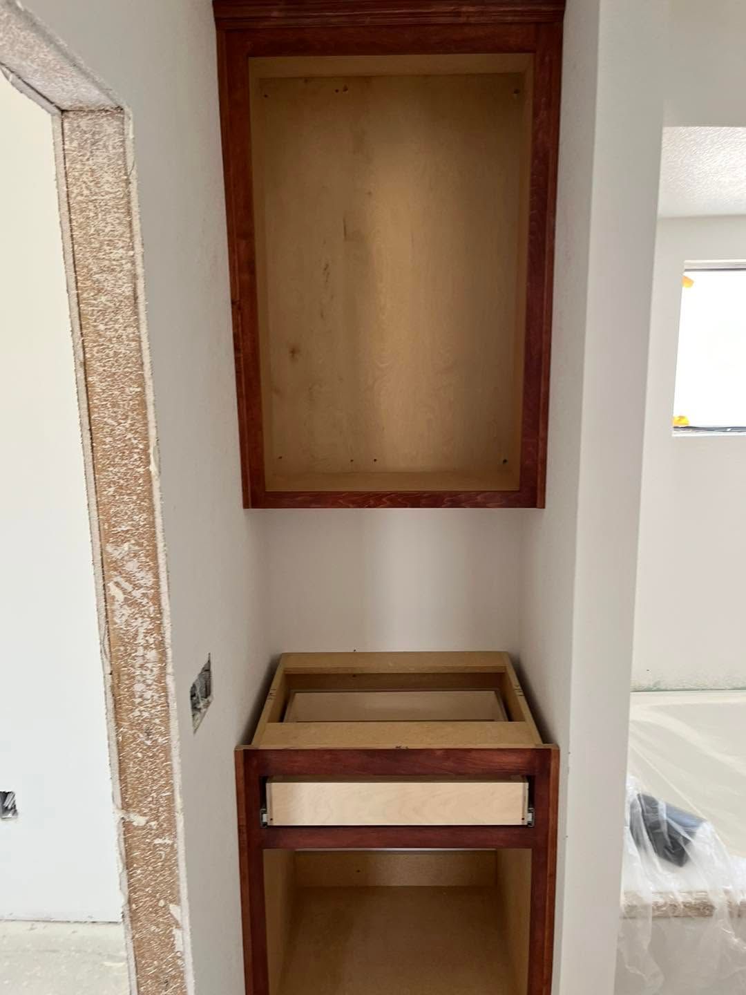 Small unfinished bathroom vanity area with wood cabinet frames and wall niches under construction