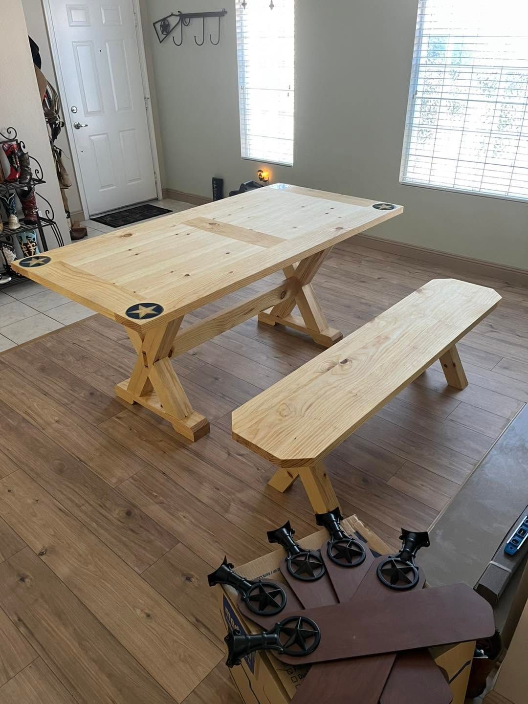 A wooden table and bench in a room, with caster wheels attached to the bench legs.