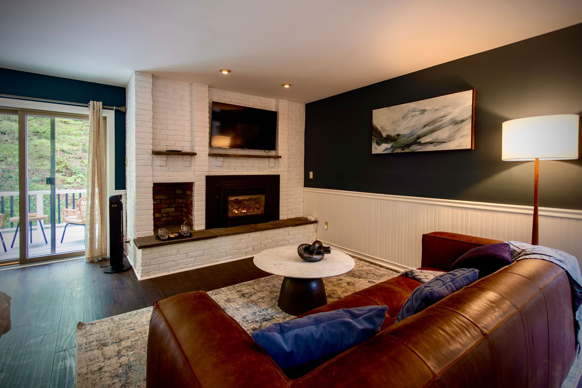 A living room with a couch , fireplace and television.