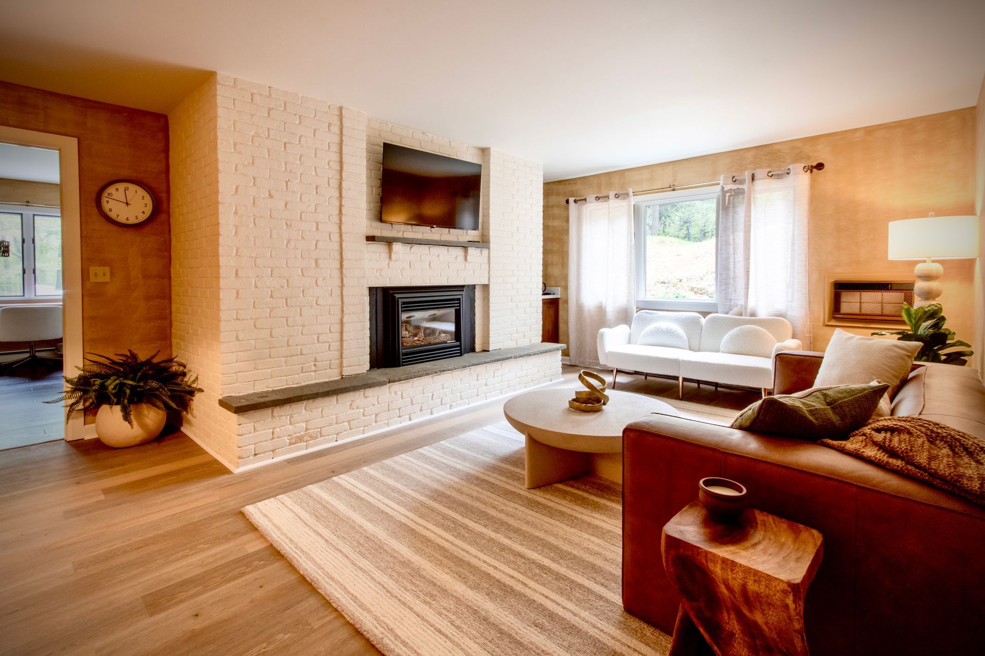 A living room with a couch , table , fireplace and television.