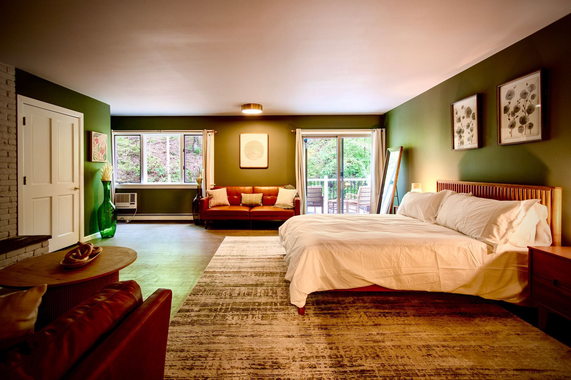 A large bedroom with a king size bed , a couch , and a rug.