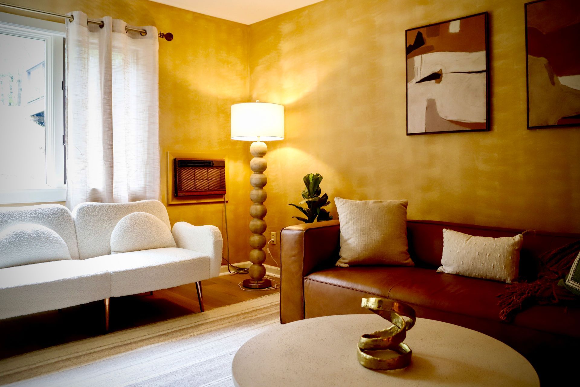 A living room with a brown couch and a white couch