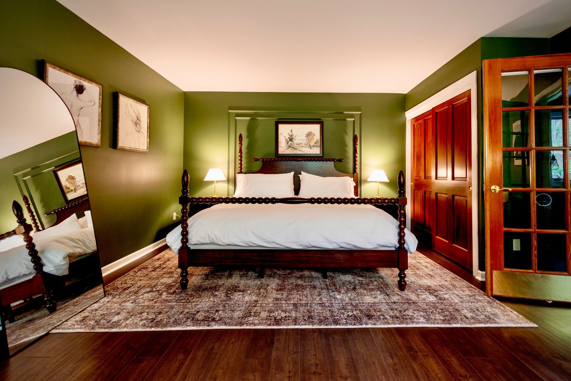 A bedroom with green walls and a four poster bed