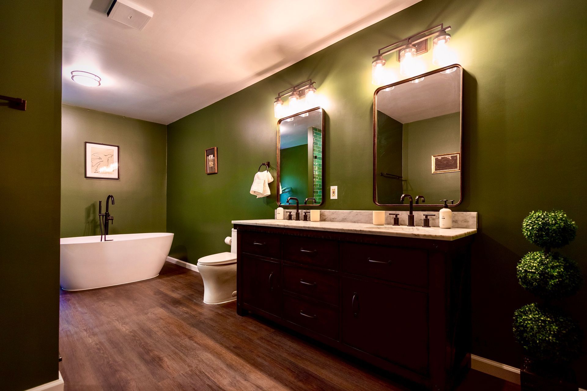 A bathroom with green walls and two sinks