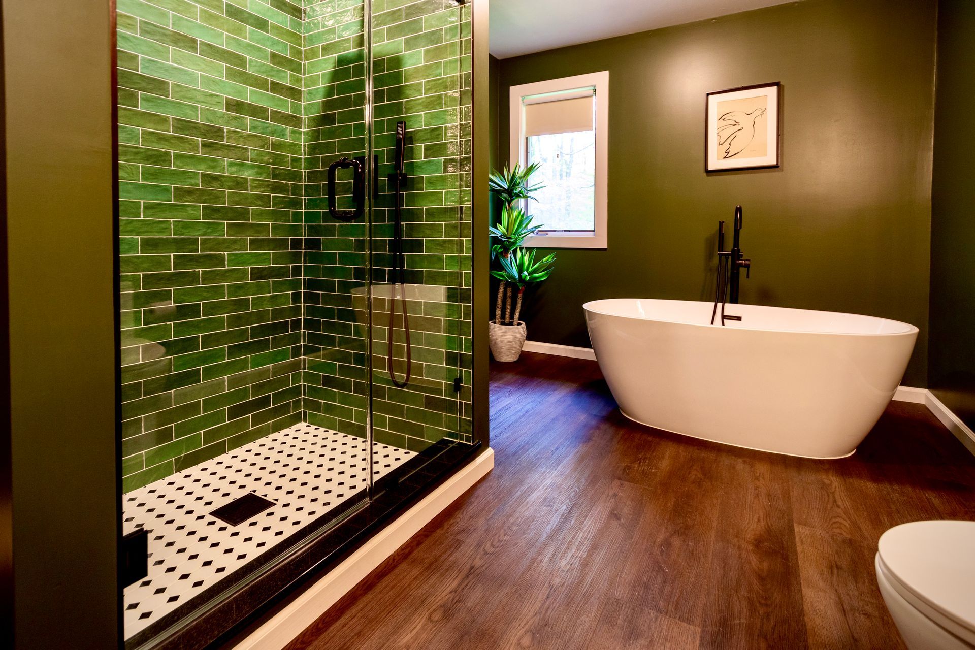 A bathroom with a tub , shower , toilet and green walls.