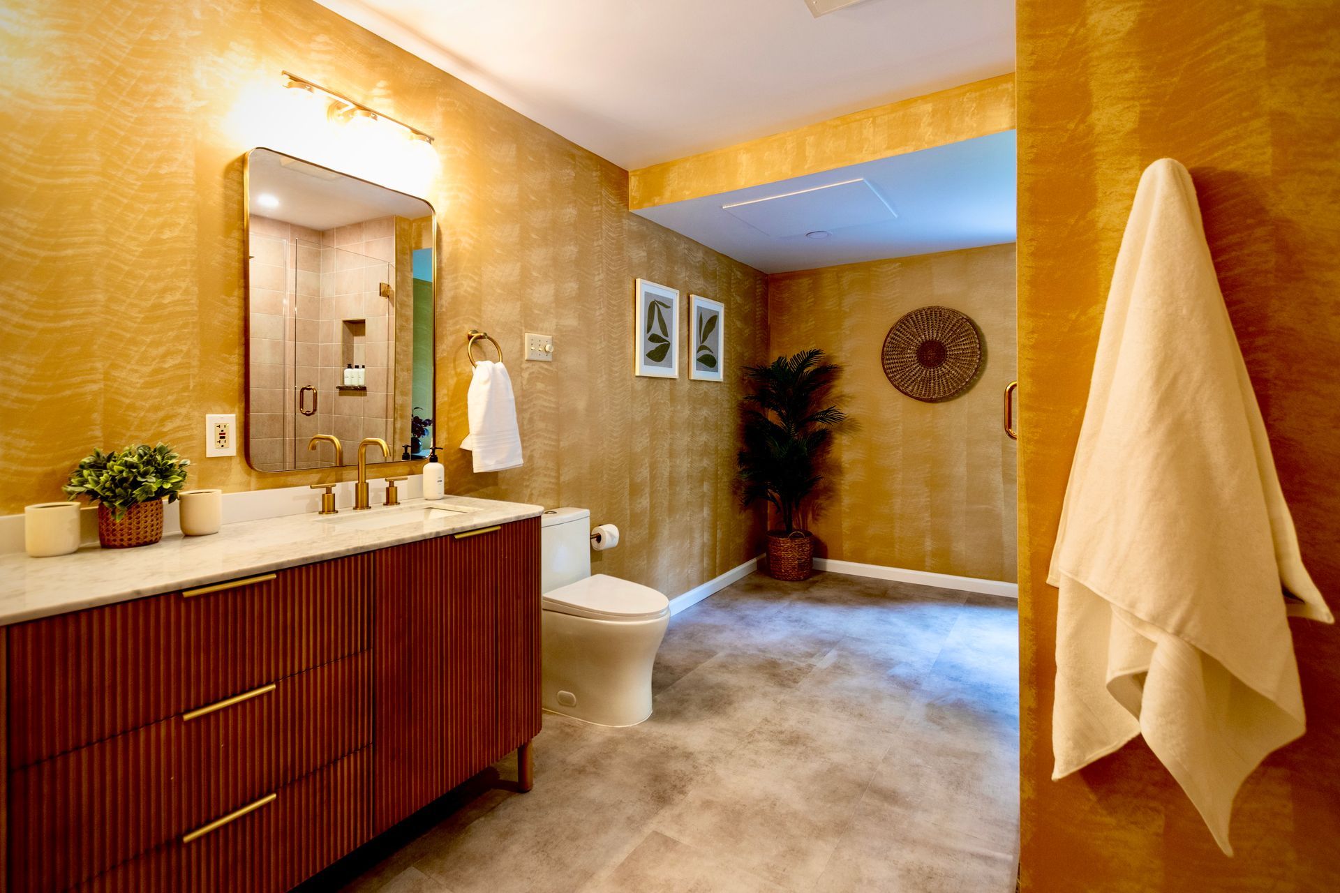 A bathroom with a toilet , sink , mirror and towel hanging on the wall.