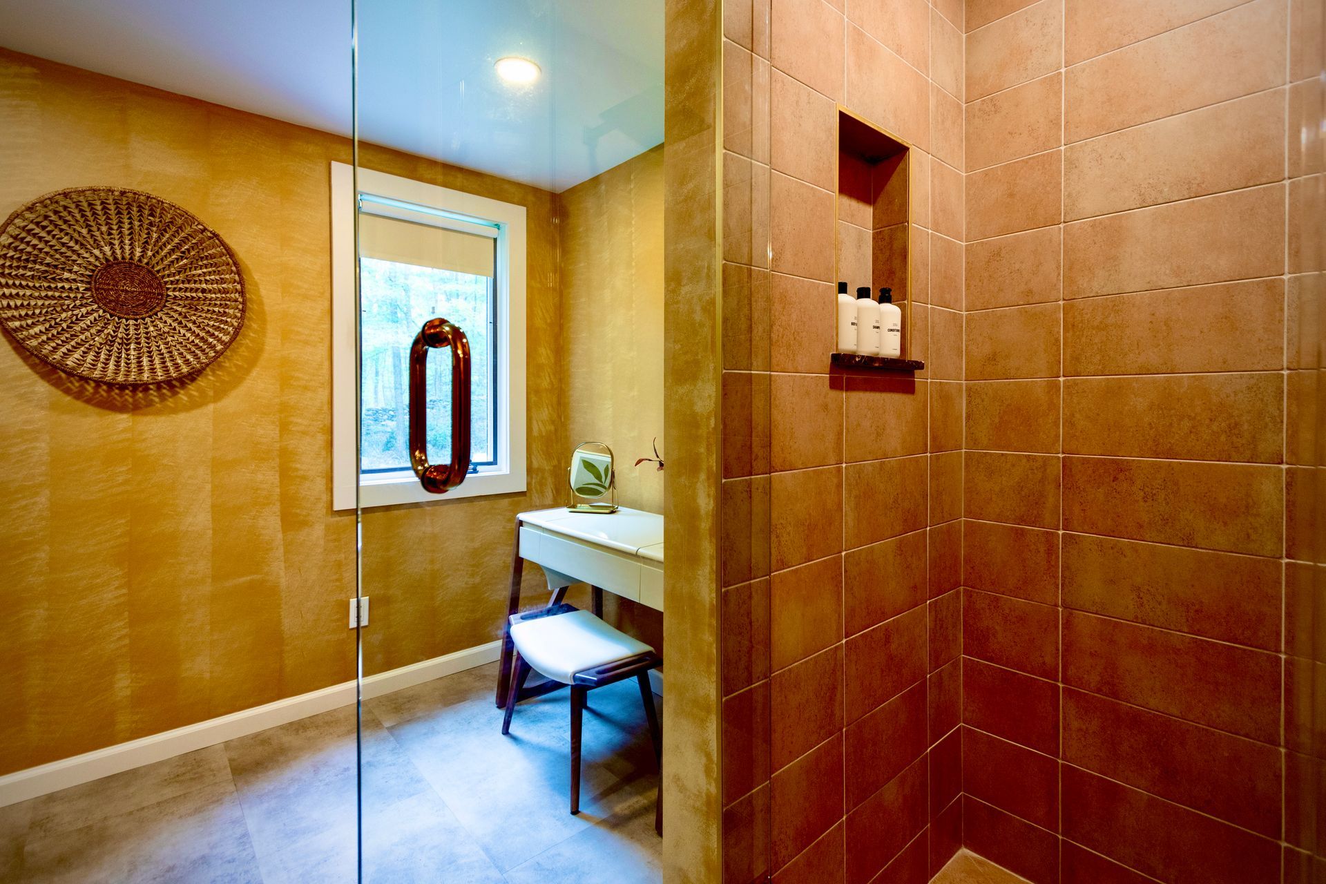 A bathroom with a walk in shower and a dressing table