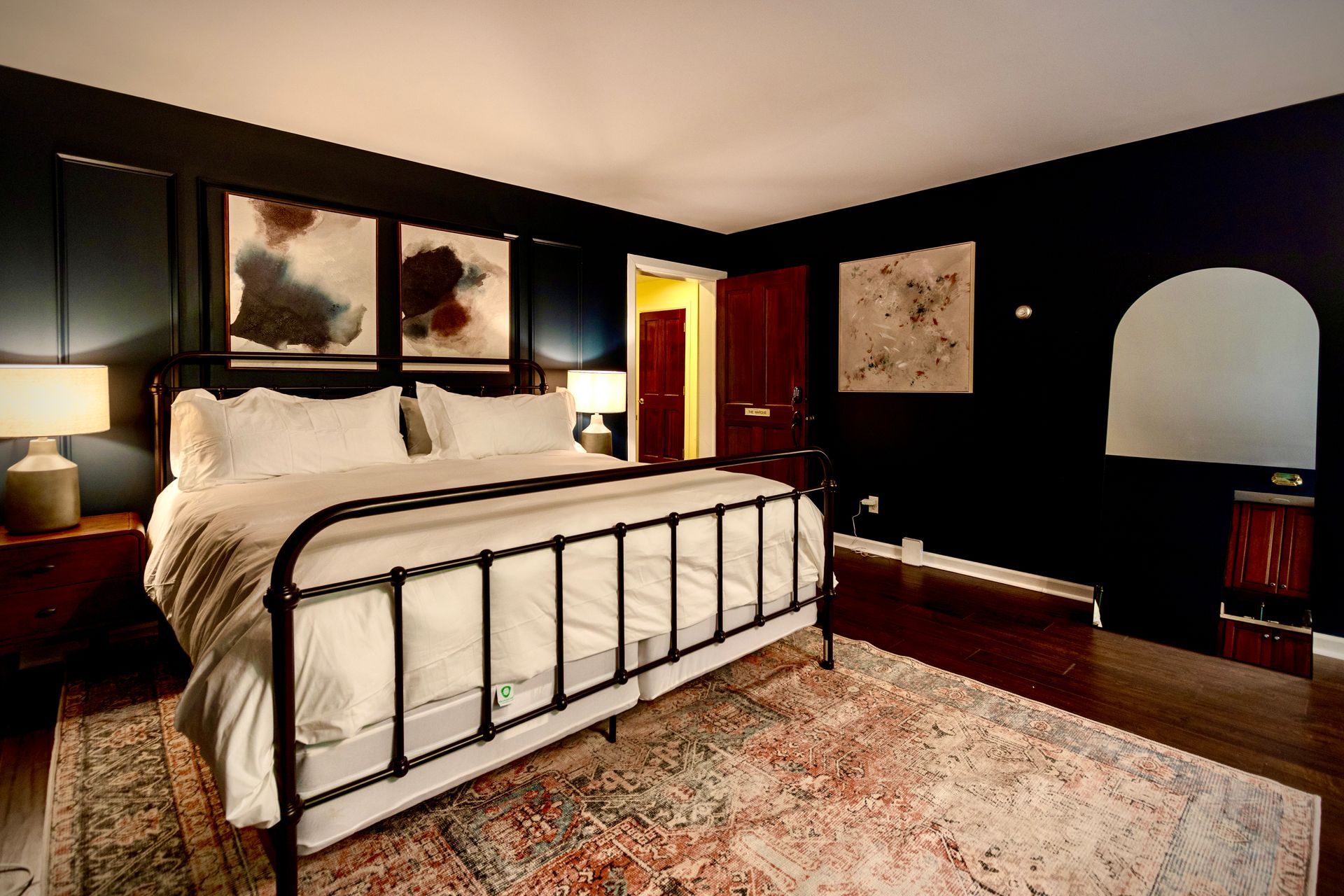 A bedroom with a king size bed and black walls