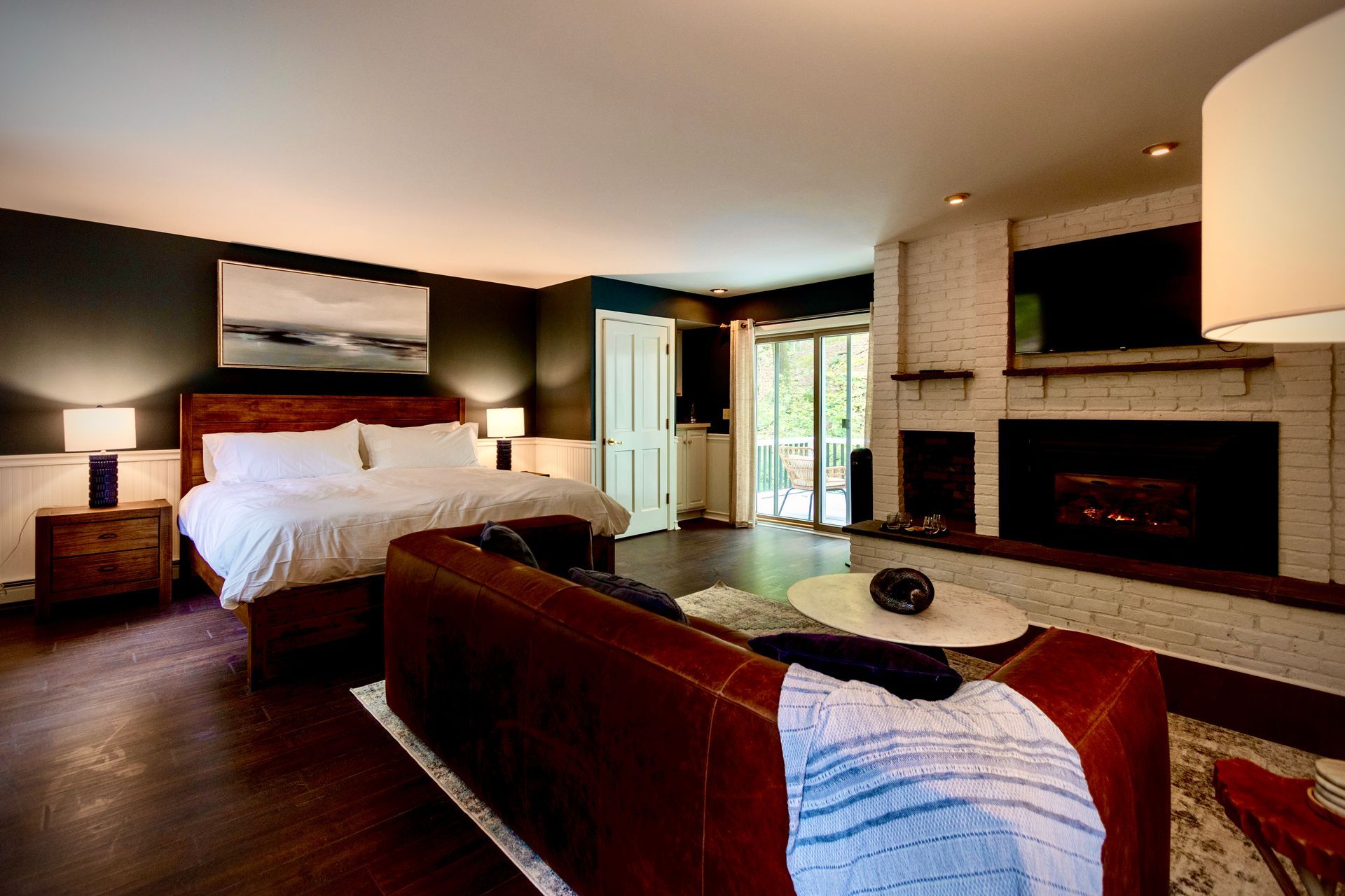 A living room with a bed , couch , fireplace and television.