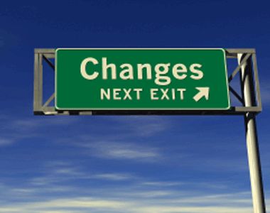Green highway sign reading “Changes” with “Next Exit” and a right arrow against blue sky