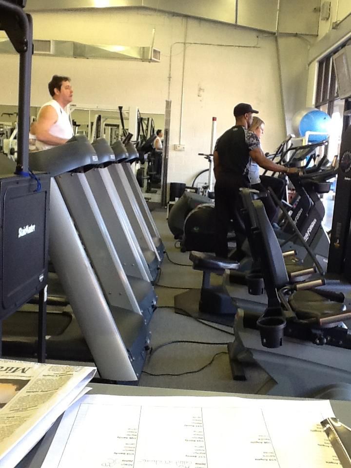 A man is riding an exercise bike in a gym