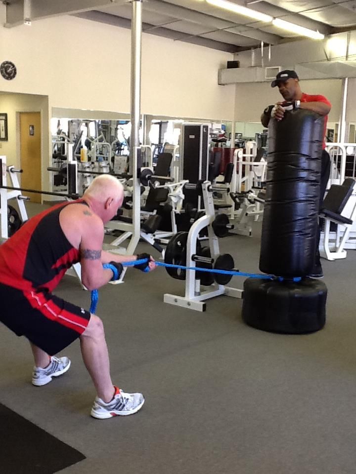 A man is pulling a rope in a gym