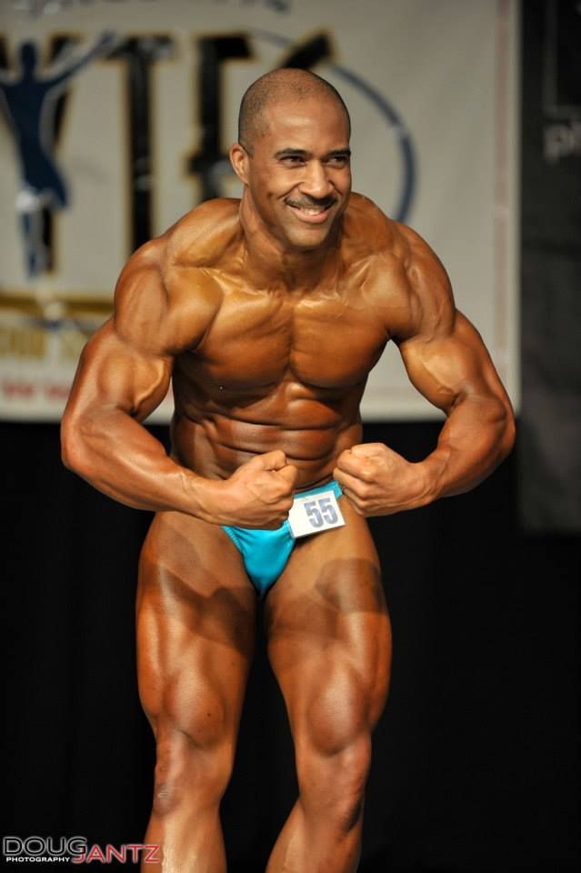 A bodybuilder with the number 55 on his shorts