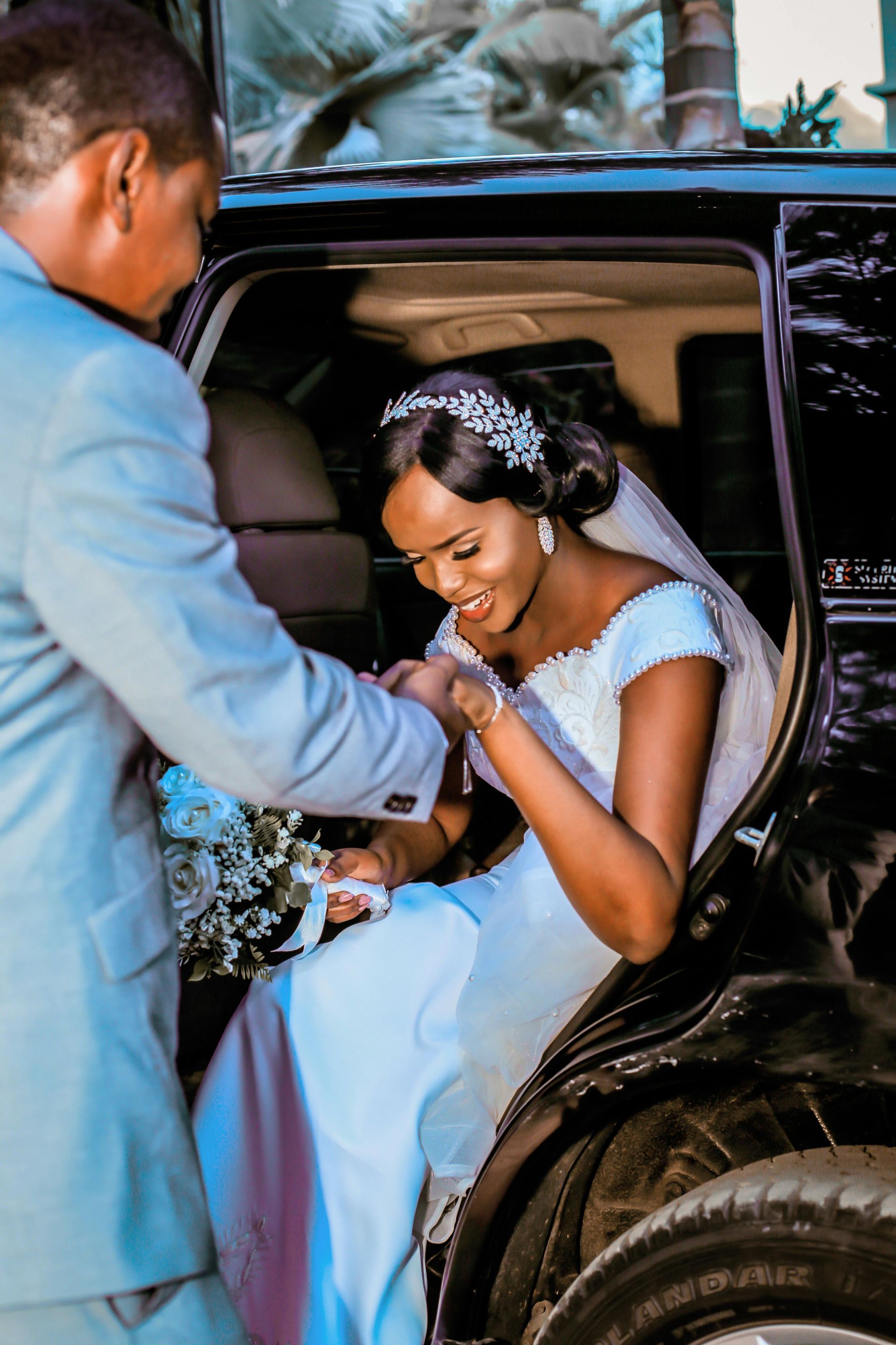 A bride and groom are getting out of a car
