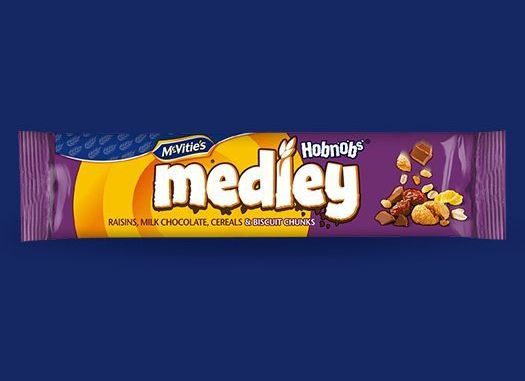 A bar of medley chocolate with nuts on a blue background