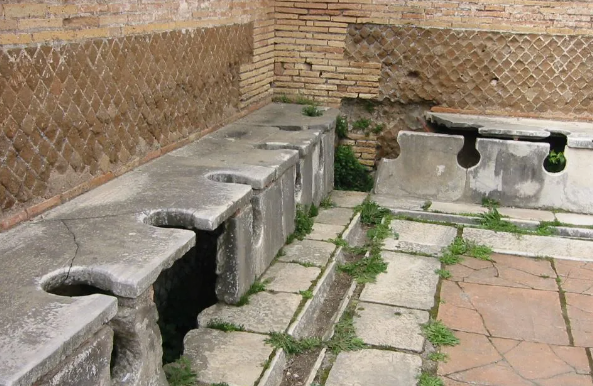 Outdoor stone wash basins and benches along a brick-walled courtyard path