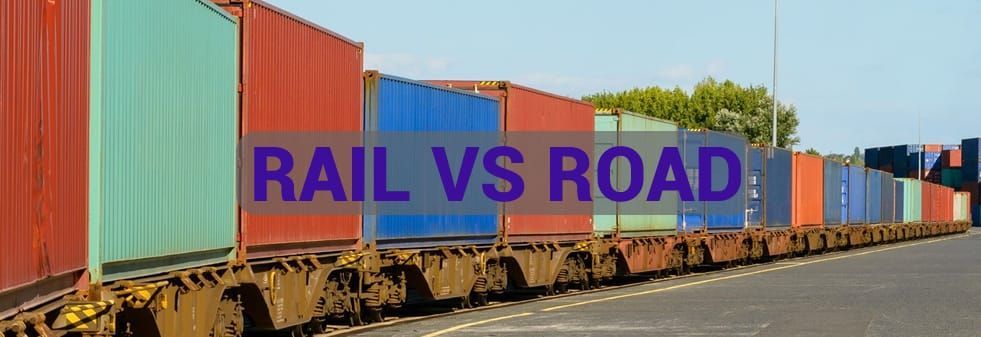 A train is going down the tracks next to a road.
