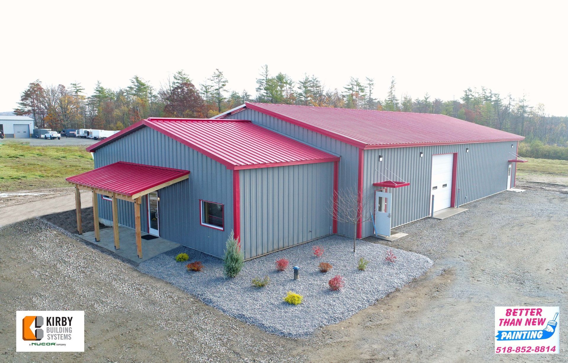 An aerial view of a large metal building with a red roof.