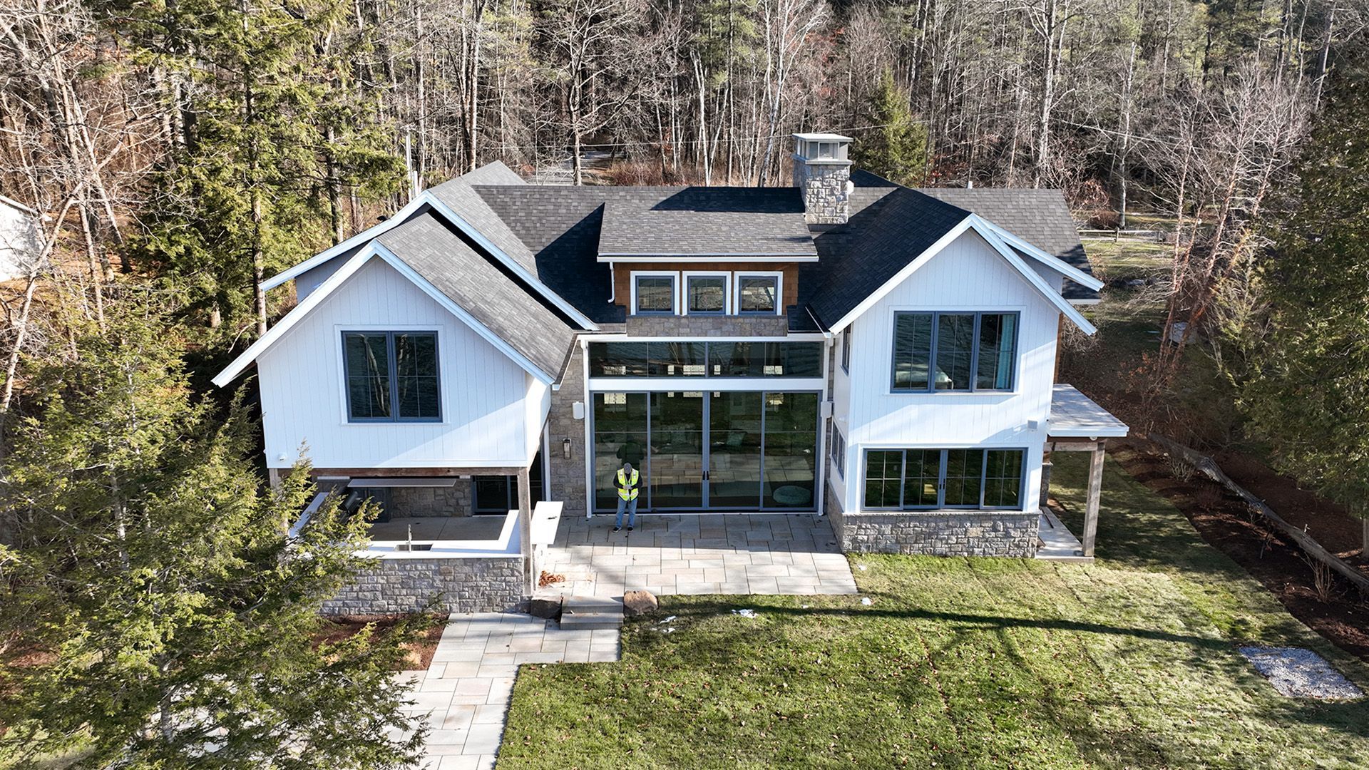 An aerial view of a large white house surrounded by trees.