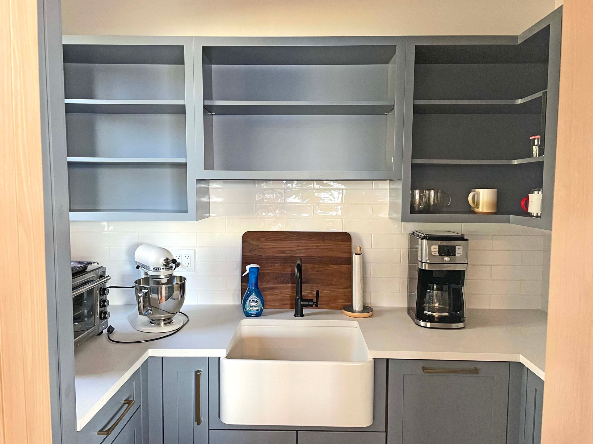 A kitchen with a sink , mixer , and coffee maker.