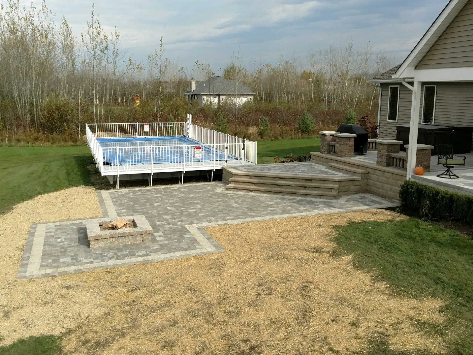 A backyard with a fire pit and a pool