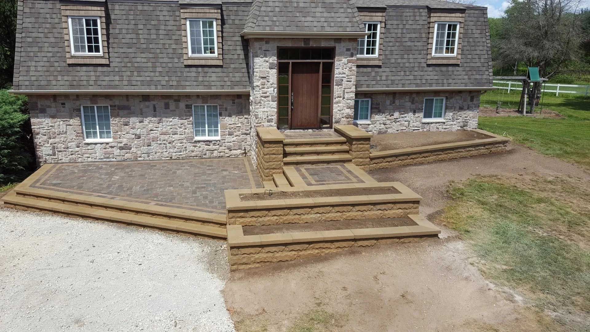 A large stone house with stairs leading up to the front door
