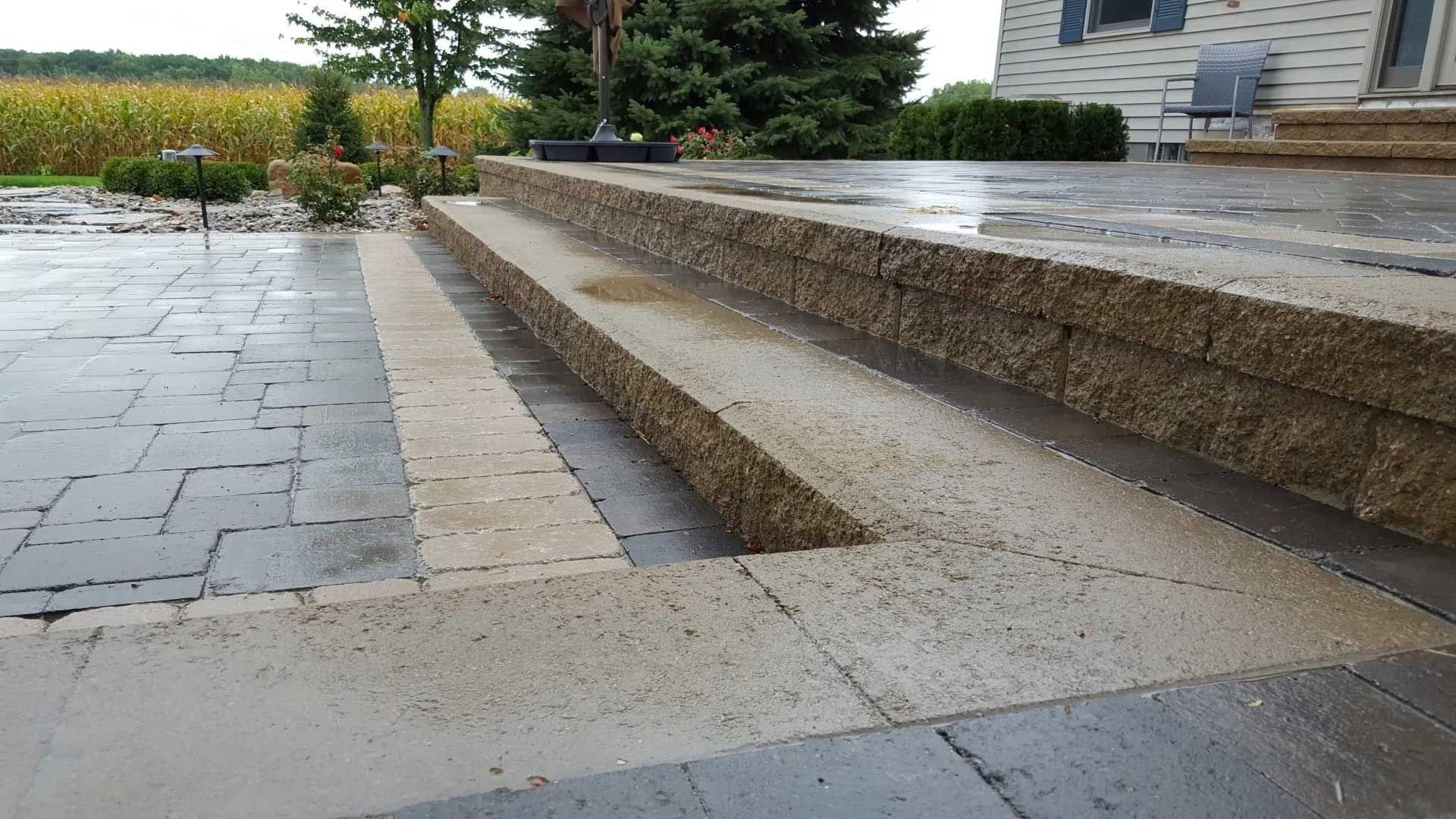 A set of stairs leading up to a patio in front of a house.