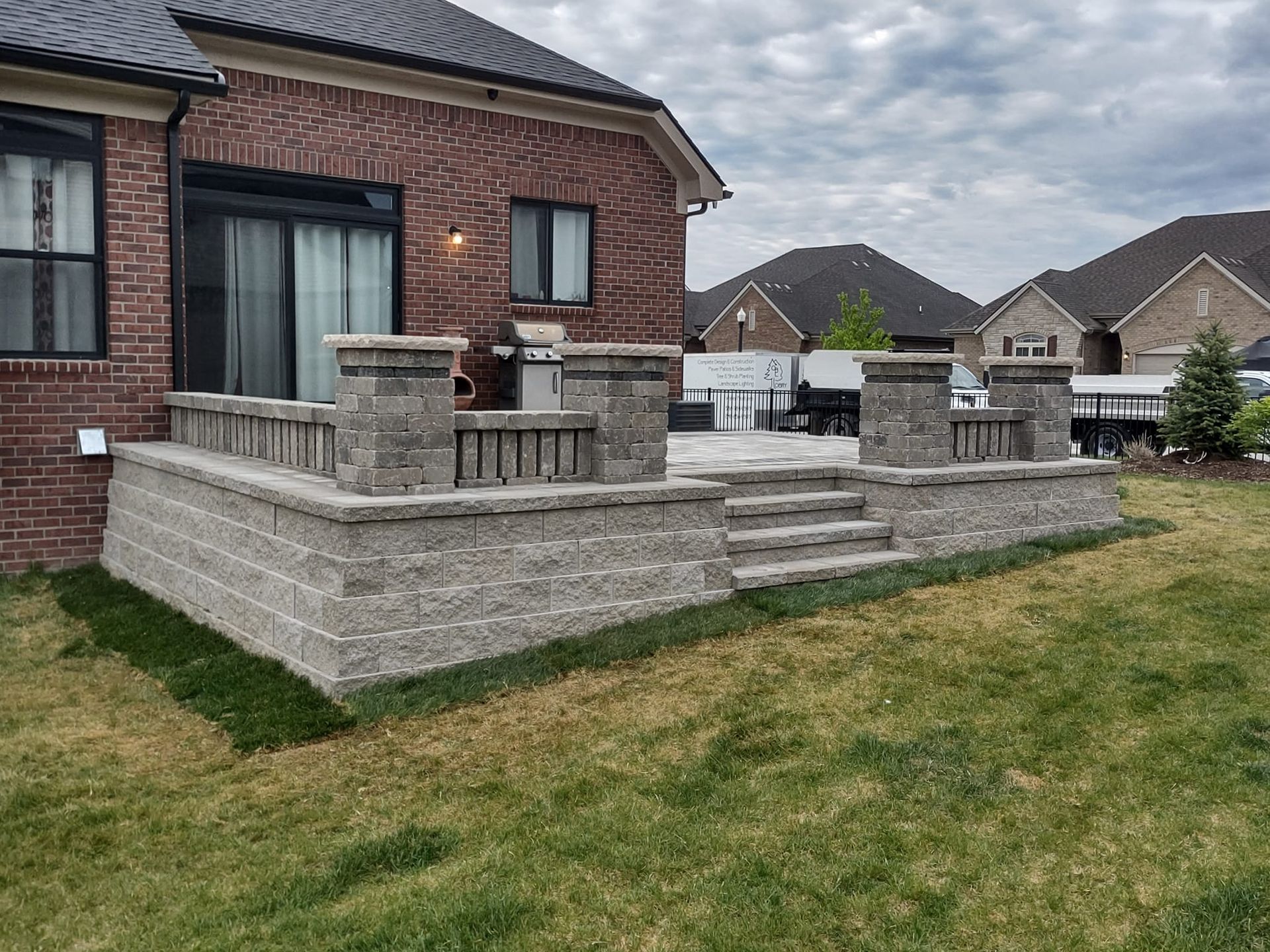 A brick house with a patio and stairs in front of it.