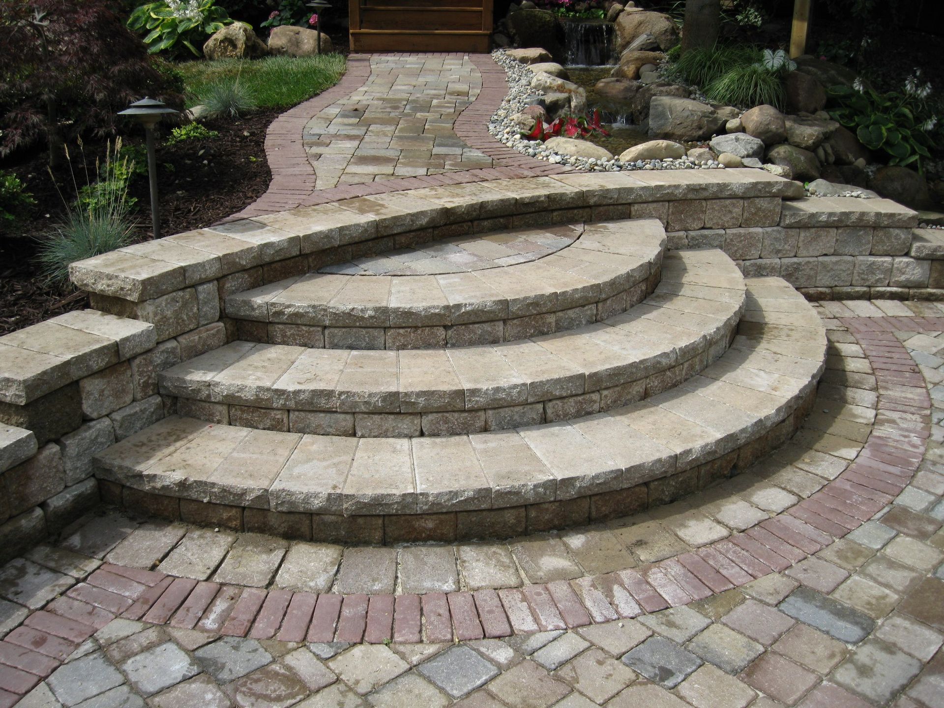 Natural and pre-cast steps installed leading up to a brick walkway