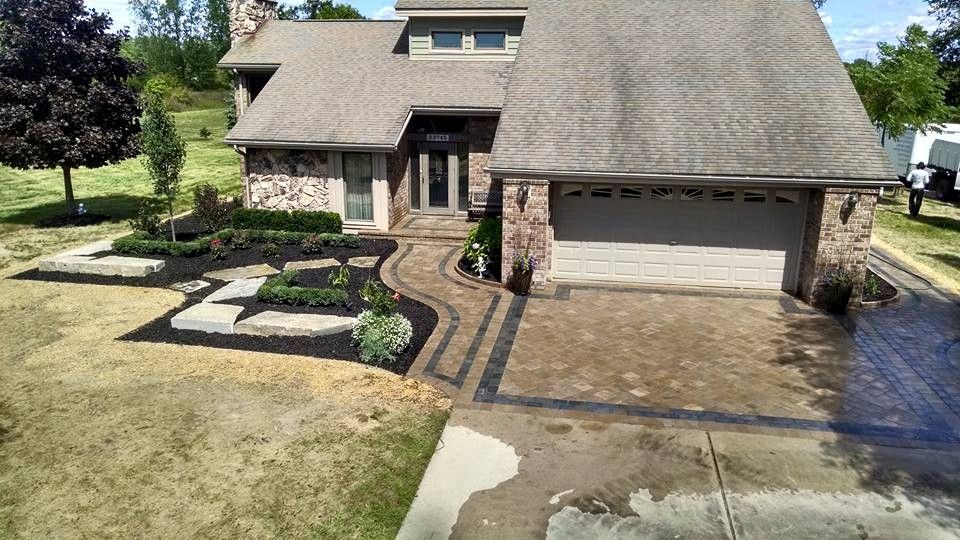 An aerial view of a large house with a garage and a driveway.
