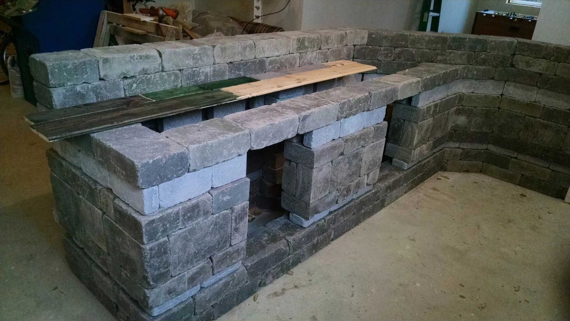 A brick wall is being built in a room.