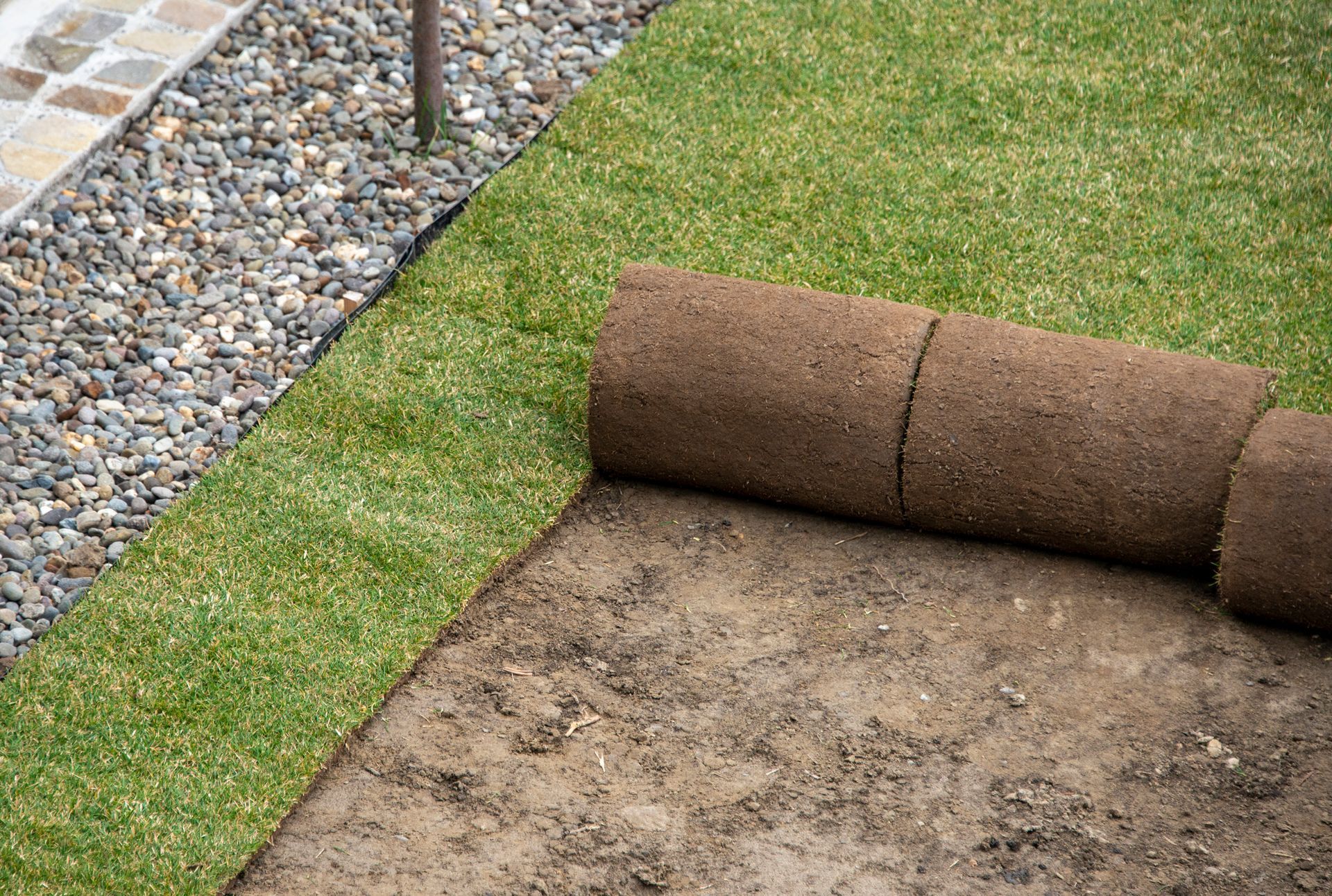 A roll of sod is sitting on top of a pile of dirt.