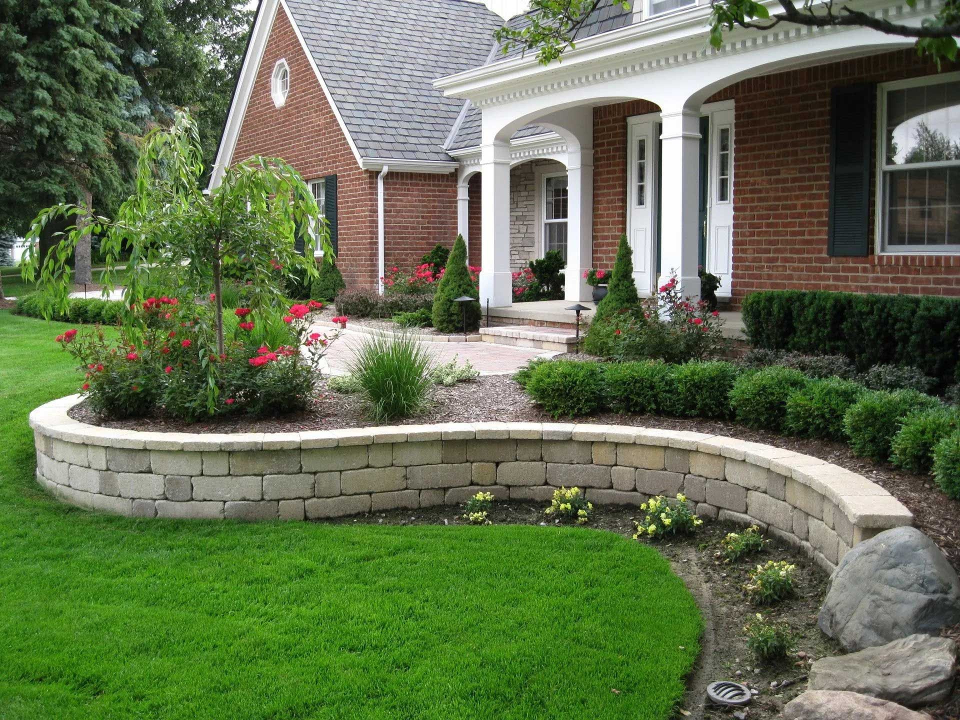 A brick house with a lush green lawn in front of it
