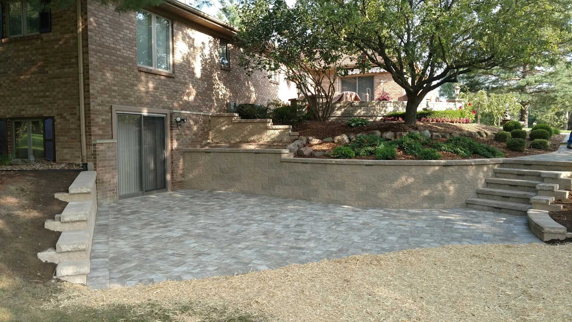 A brick house with a patio and stairs in front of it.