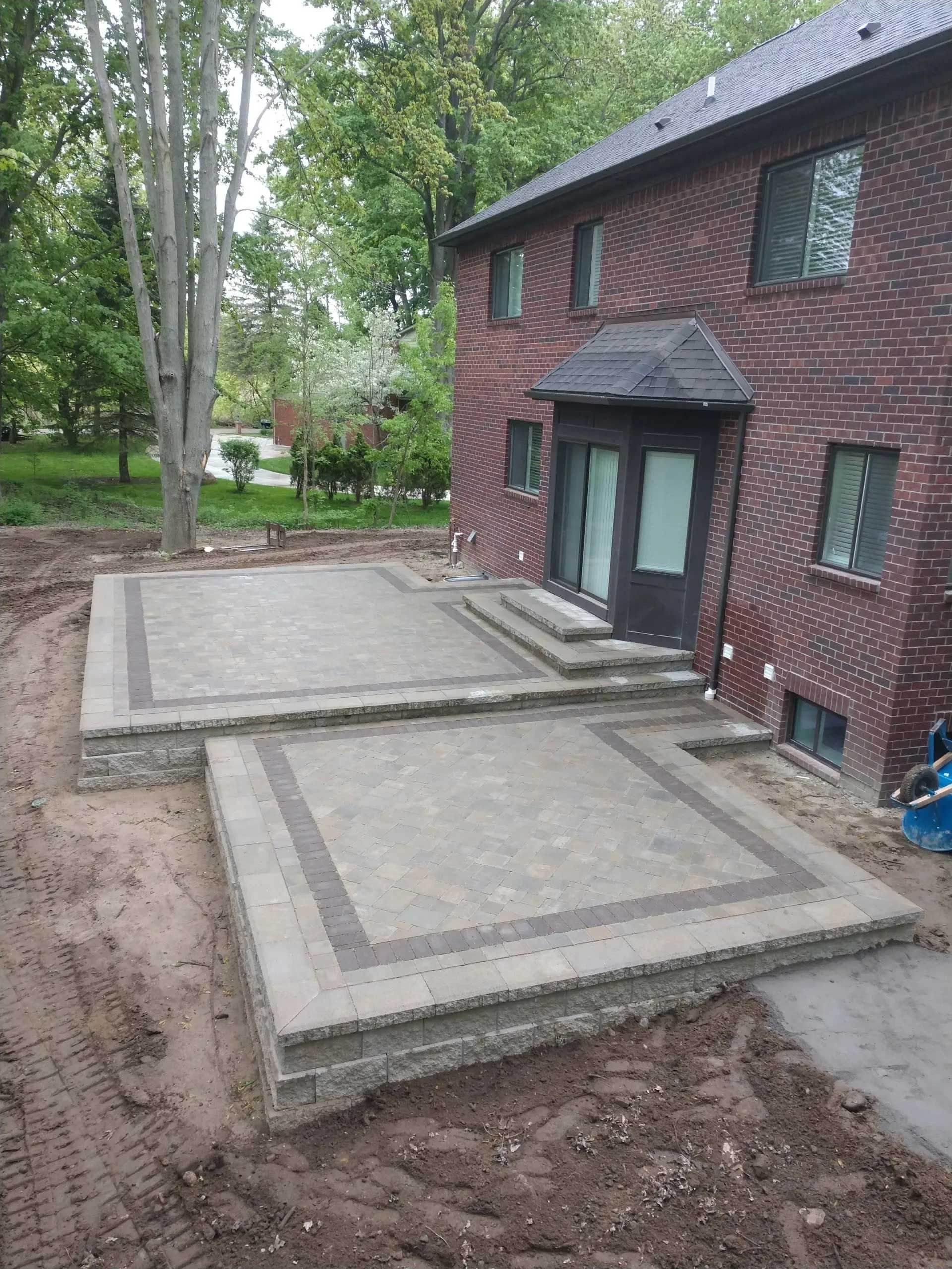A brick house with a patio in front of it.