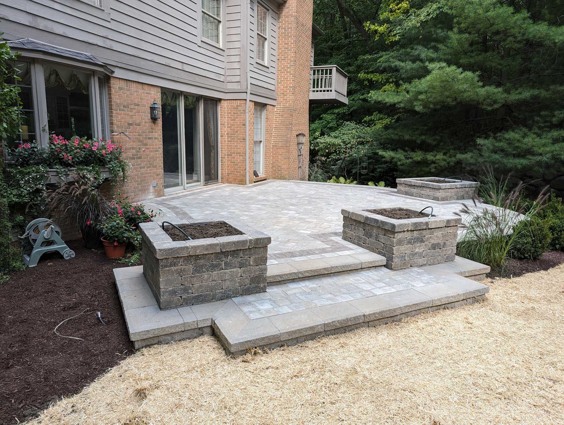 A patio with a fire pit in the backyard of a house.
